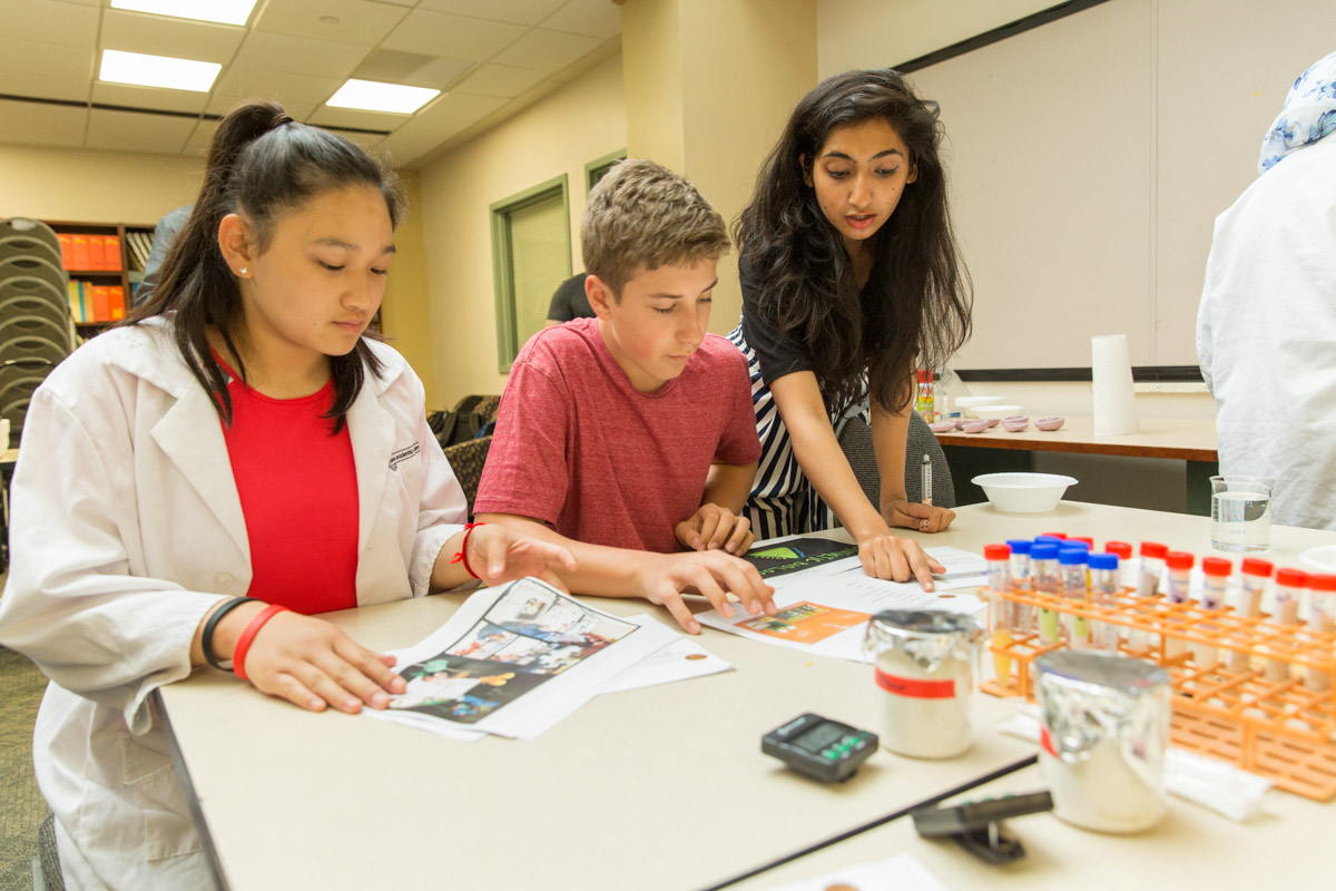 Penn graduate students work with a K-12 student in a classroom setting.