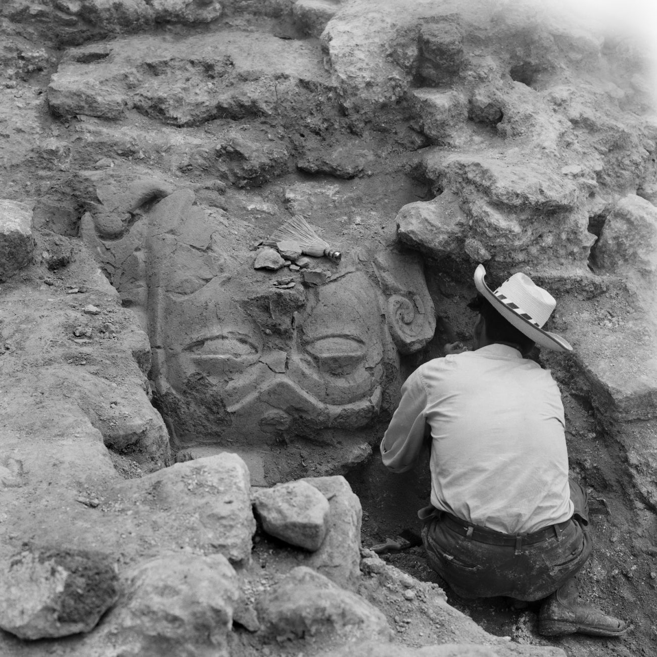 Upside-down sculpture of a face being uncovered in Structure 34 of the North Acropolis at Tikal, 1962