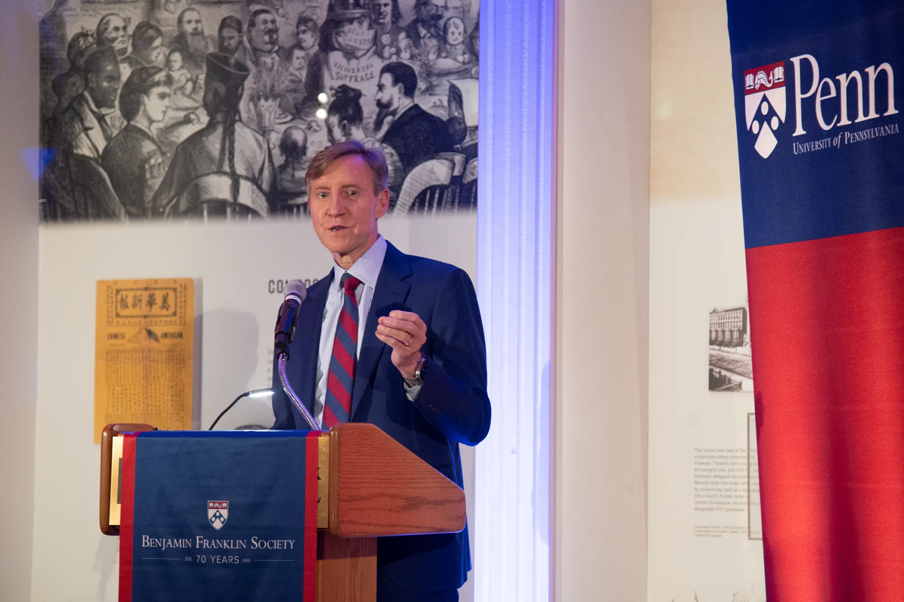 Penn President J. Larry Jameson speaks at a podium during a Benjamin Franklin Society event, with University of Pennsylvania branding in the background.
