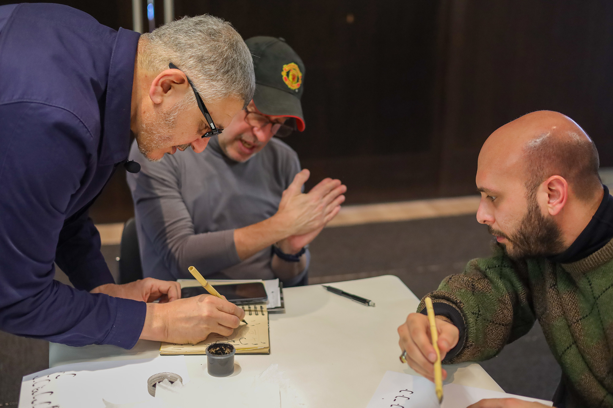 American-Arab artist and professor of mechanical engineering Nihad Dukhan (left) leads a workshop on Islamic calligraphy.