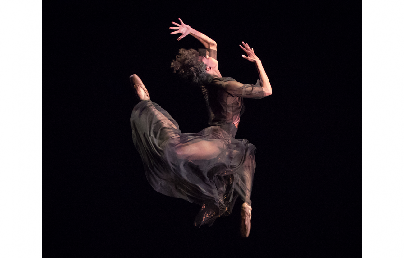 ballet dancer in mid air doing an attitude jump