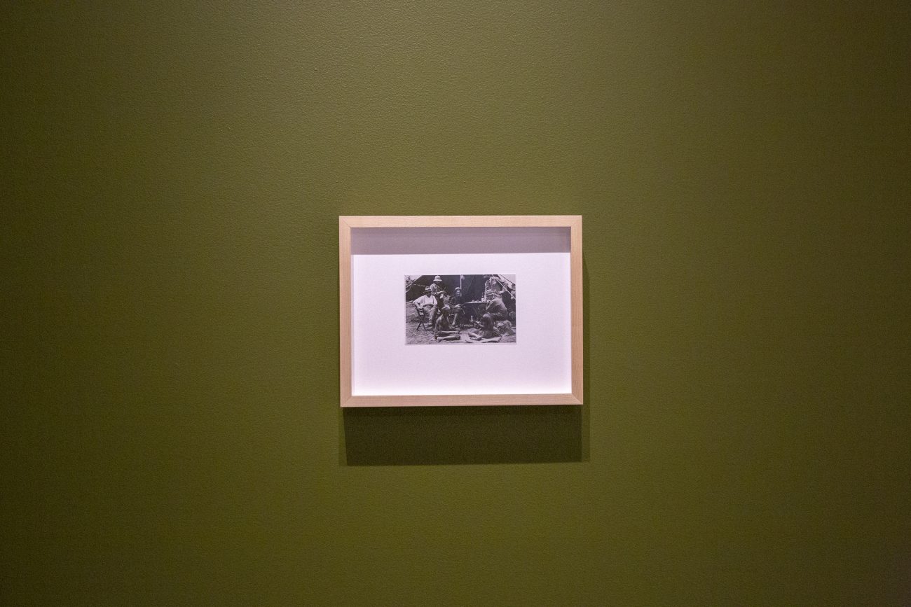 a framed black and white photo hanging on a olive green wall