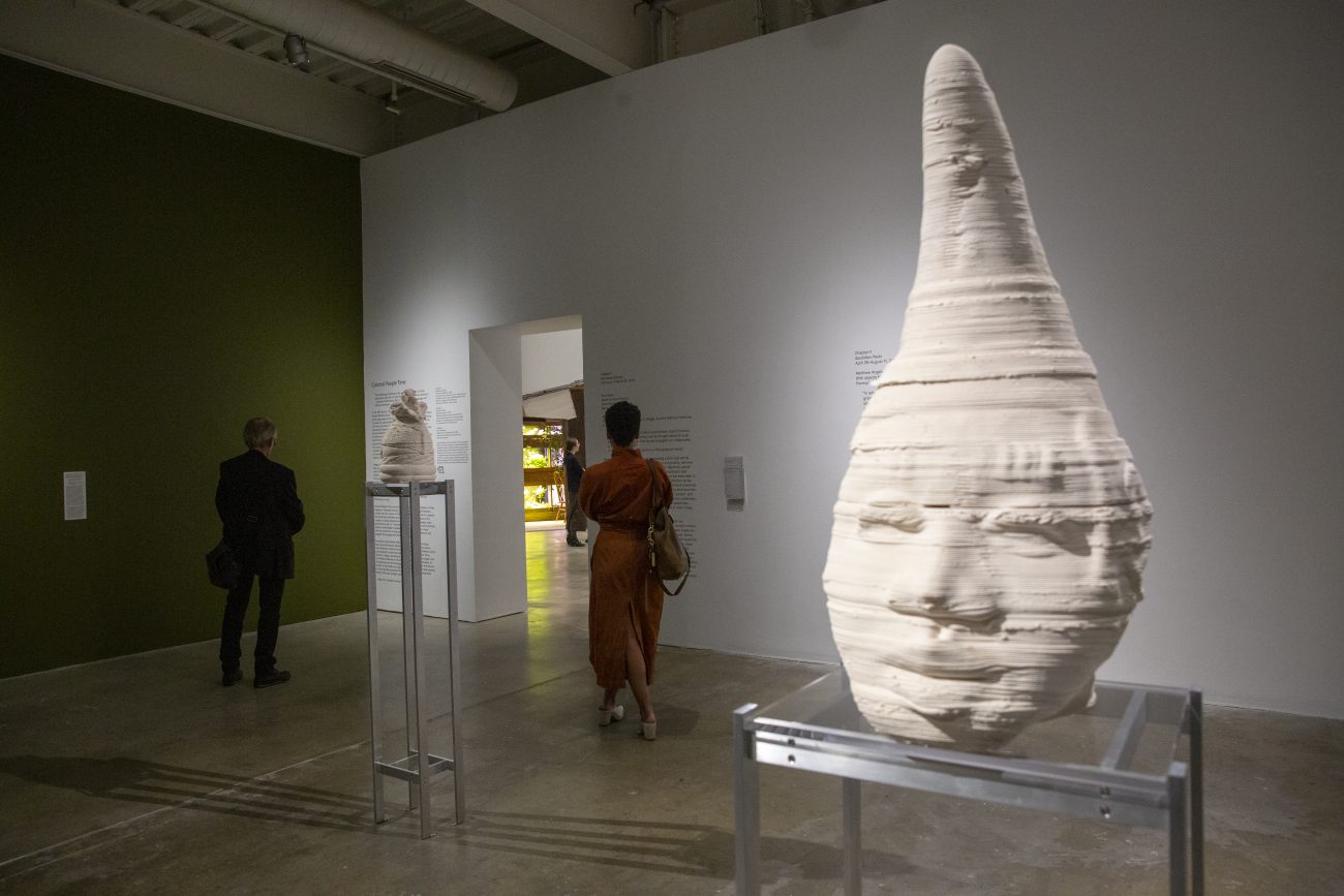 a sculpture of a face with a cone shaped head in a museum