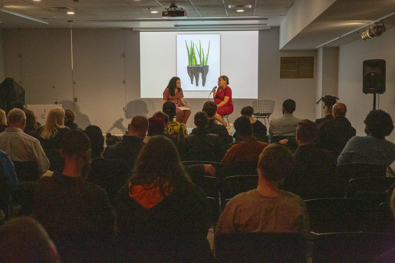 two women on stage speaking to a crowd