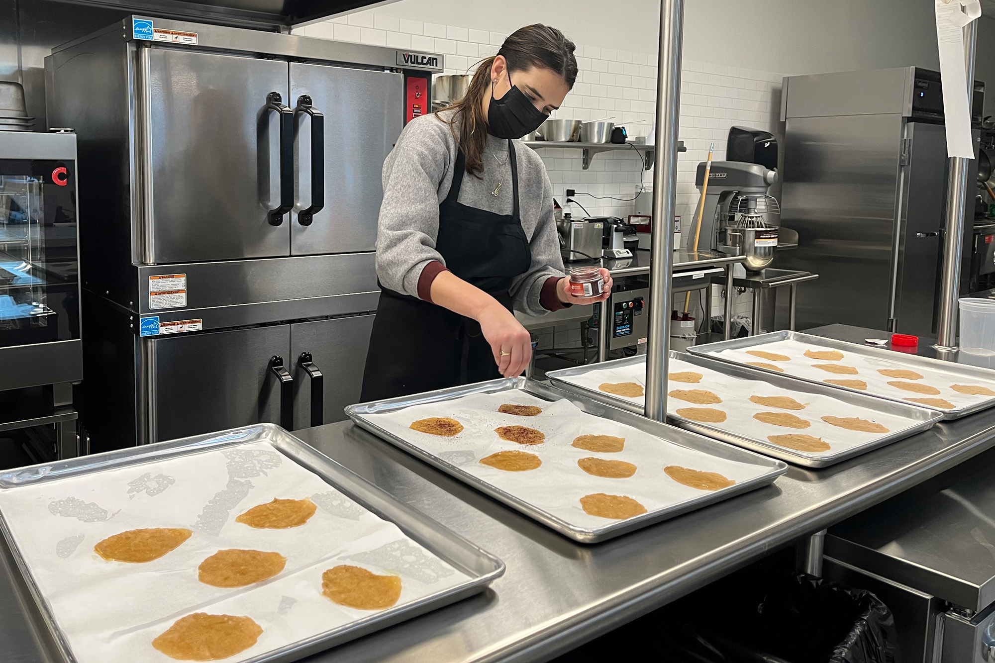 Melissa Tovin, G'22, WG'22, tests an early batch of her Sumac Sourdough Crisps in the Food Innovation Lab at Tangen Hall.