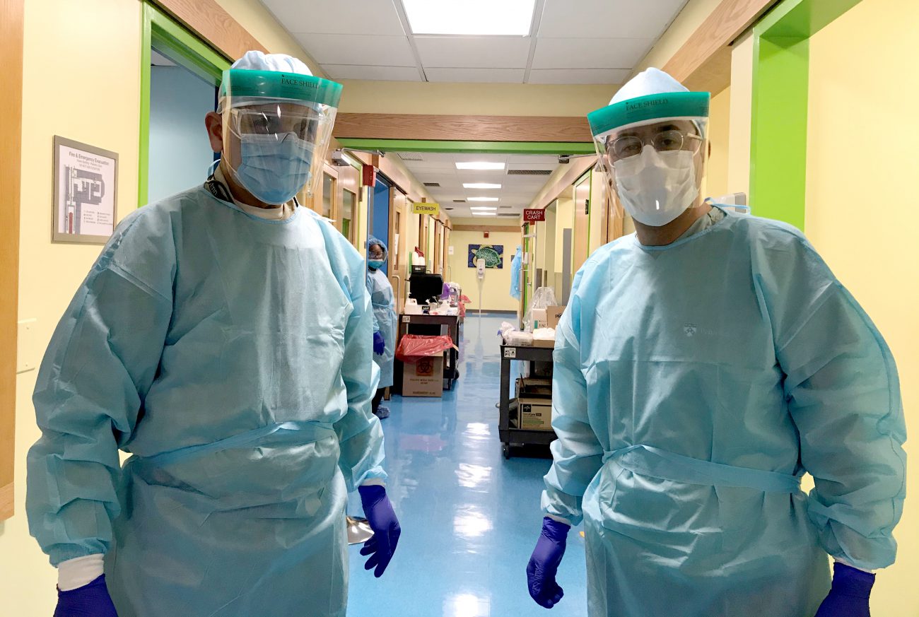 Photo of two Penn Dentists in hallway wearing protective gear