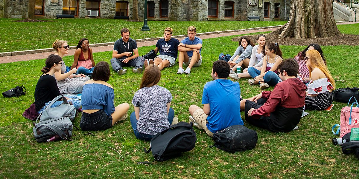 A group of students sitting in a circle outside of College Hall at the University of Pennsylvania