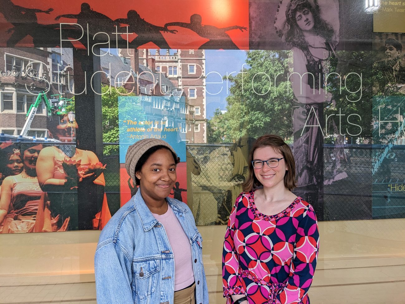 Sara Outing, C’13, Program Coordinator, and Megan Edelman, C’11, LPS’22, Associate Director, stand together outside the Platt Student Performing Arts House at the University of Pennsylvania.