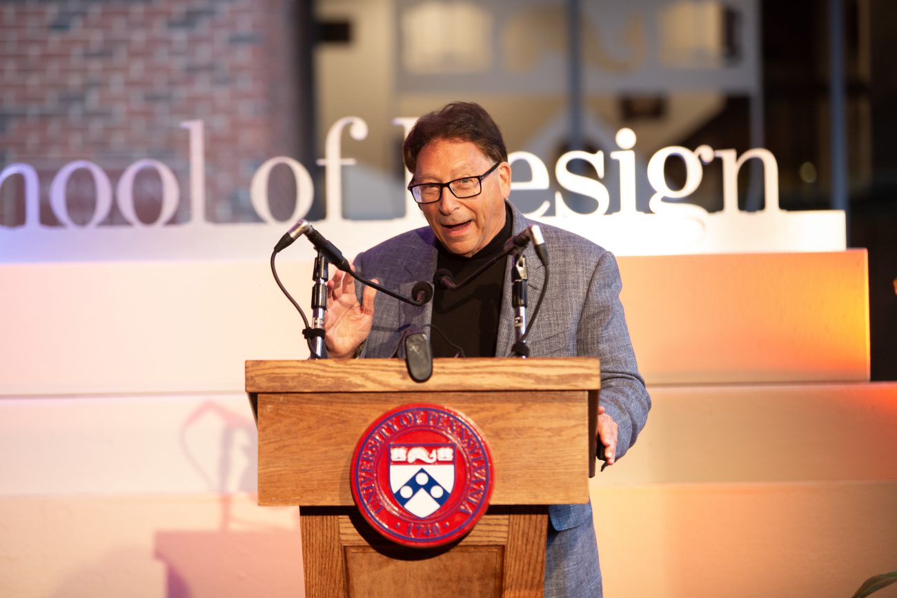 man presenting with two microphones at the weitzman naming ceremony