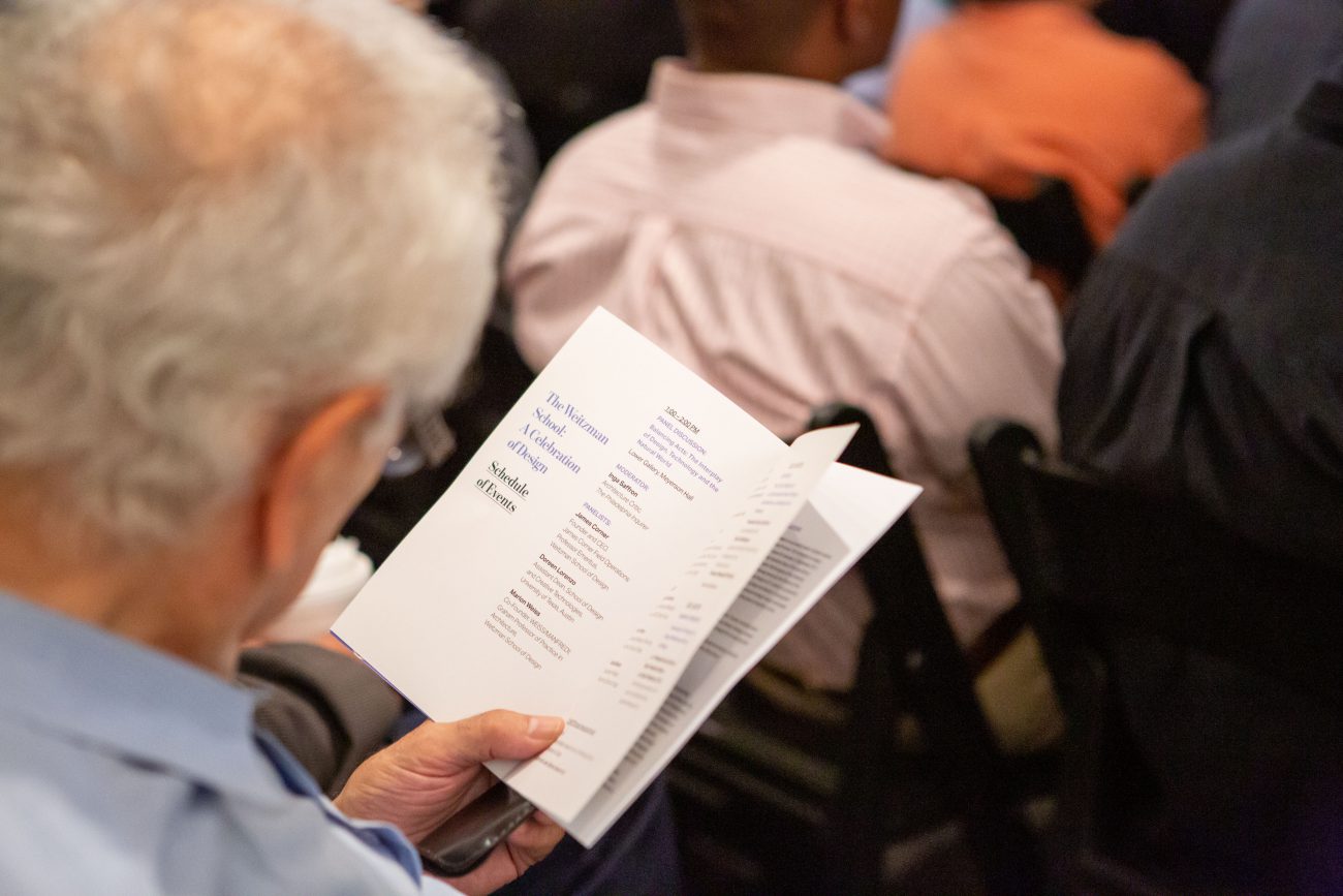 a white haired man reading a schedule of events