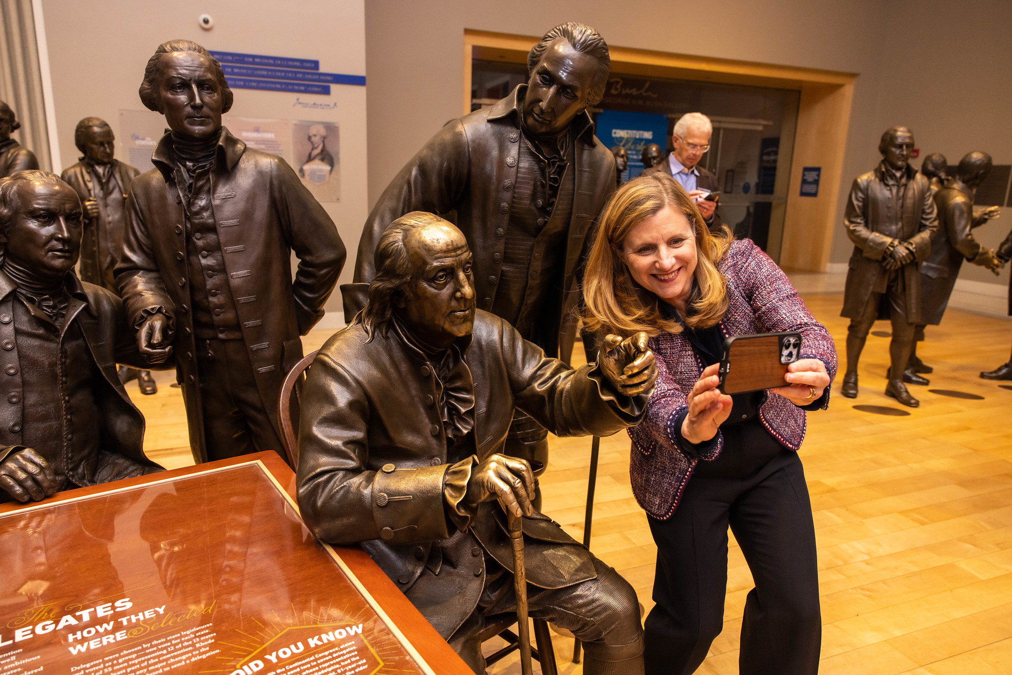 President Magill poses with a statue of University founder Benjamin Franklin during the Penn Forward Philadelphia event at the National Constitution Center.