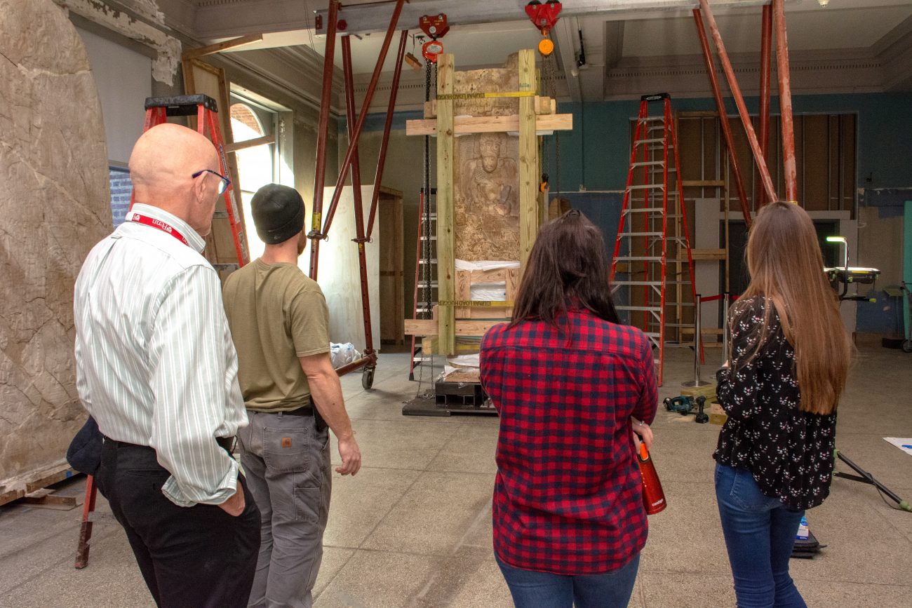 two men and two women looking at their work with their backs to the camera