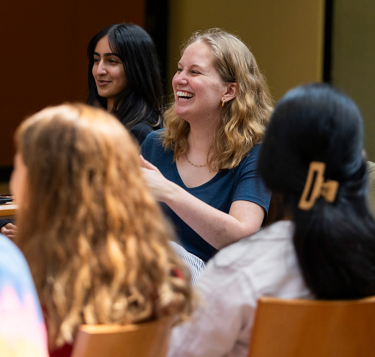 Students in the School of Social Policy and Practice at the University of Pennsylvania smile and laugh during a group discussion