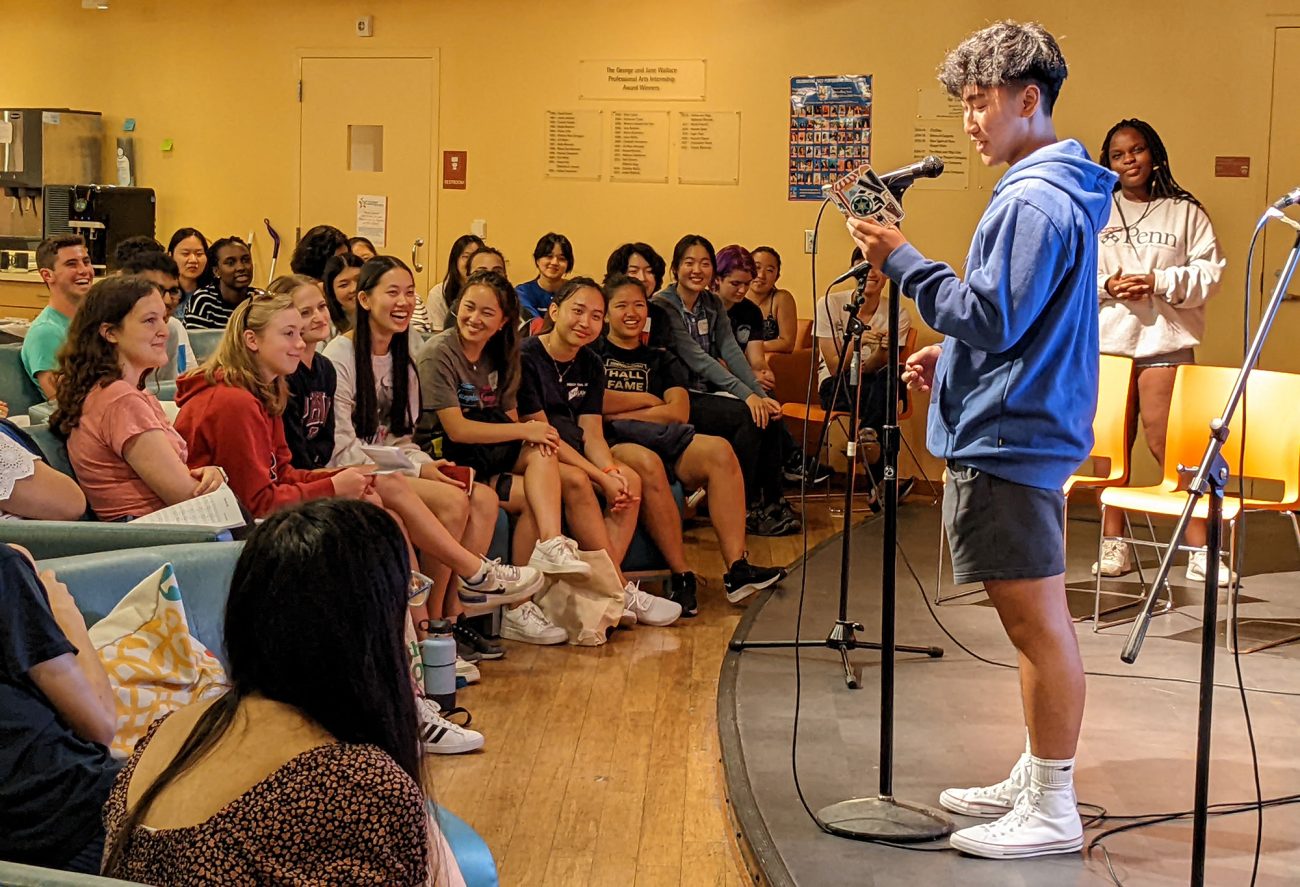 A student recites poetry in front of an audience at the Platt Student Performing Arts House at the University of Pennsylvania.