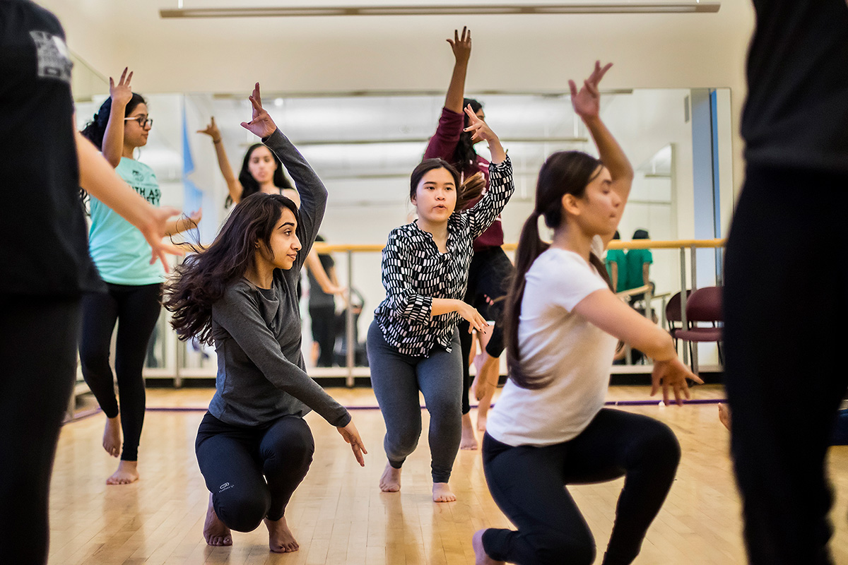 A group of students practices a dance routine together