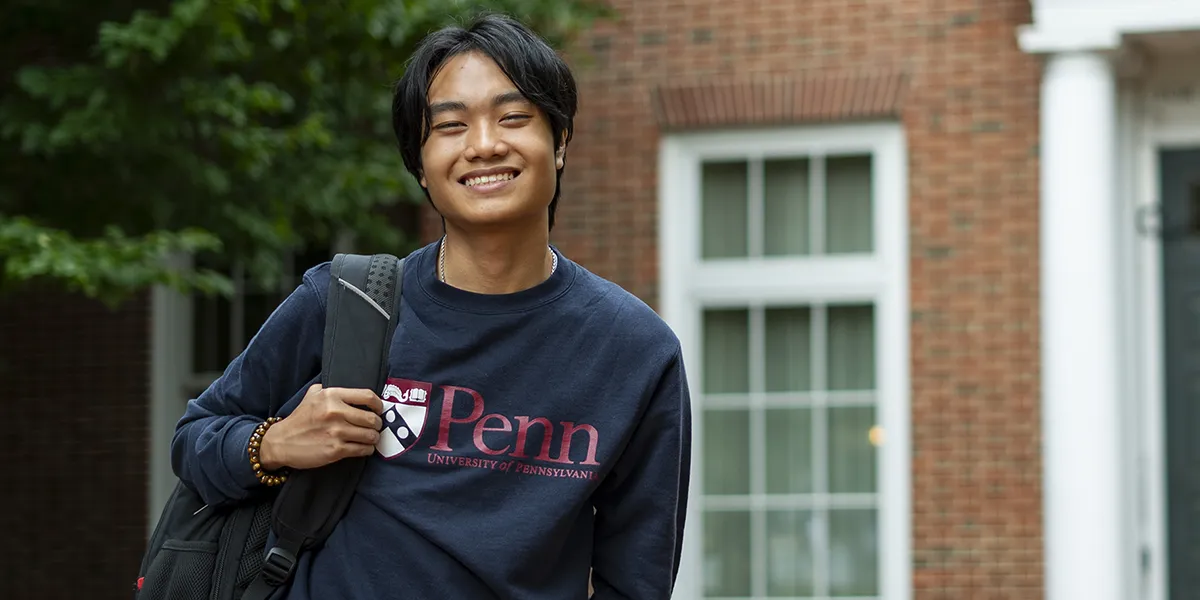 University of Pennsylvania student Andrew Luong outside a brick academic building, smiling confidently.