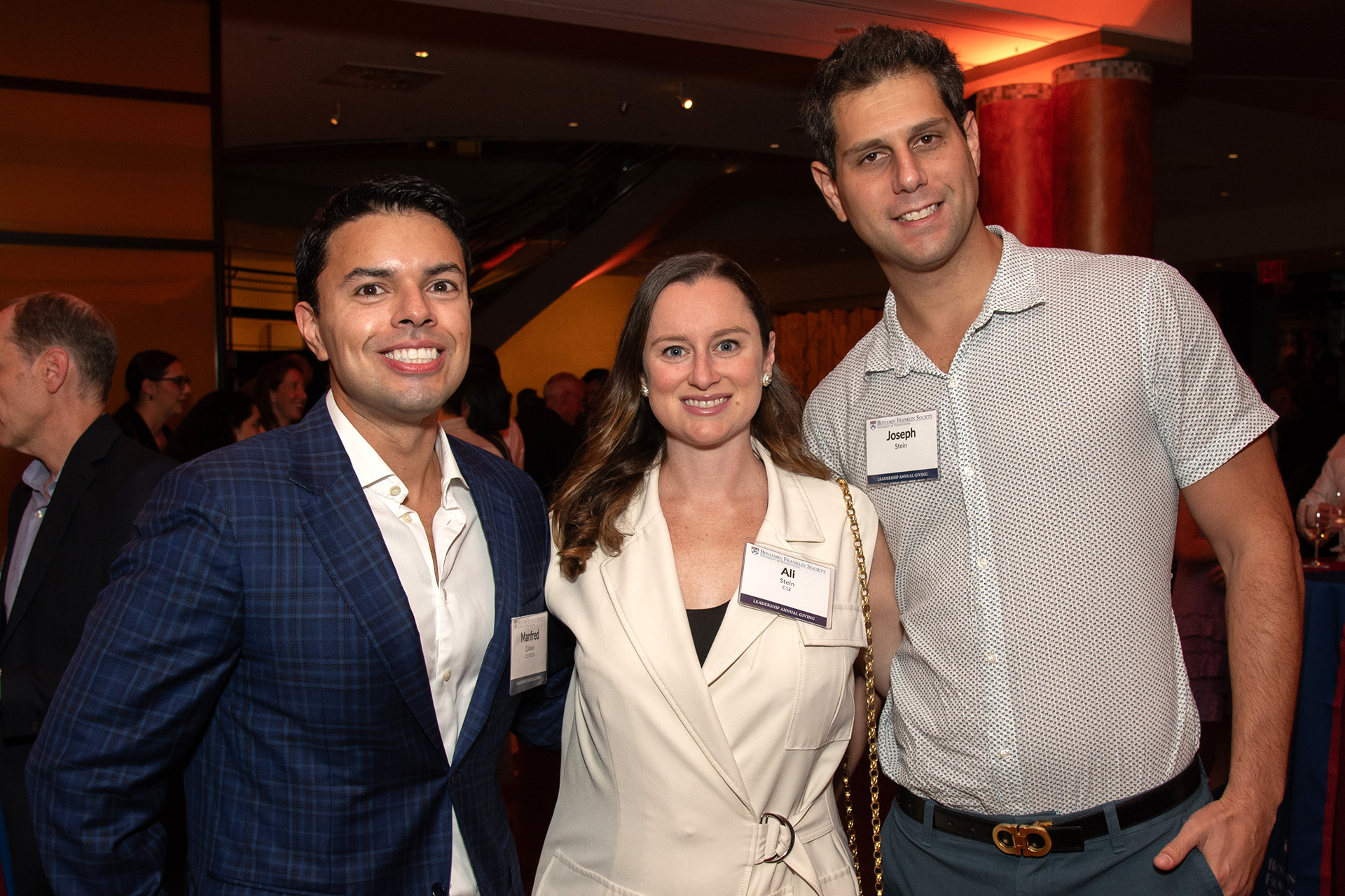 Three Penn alumni pose for a photo at a Benjamin Franklin Society event.