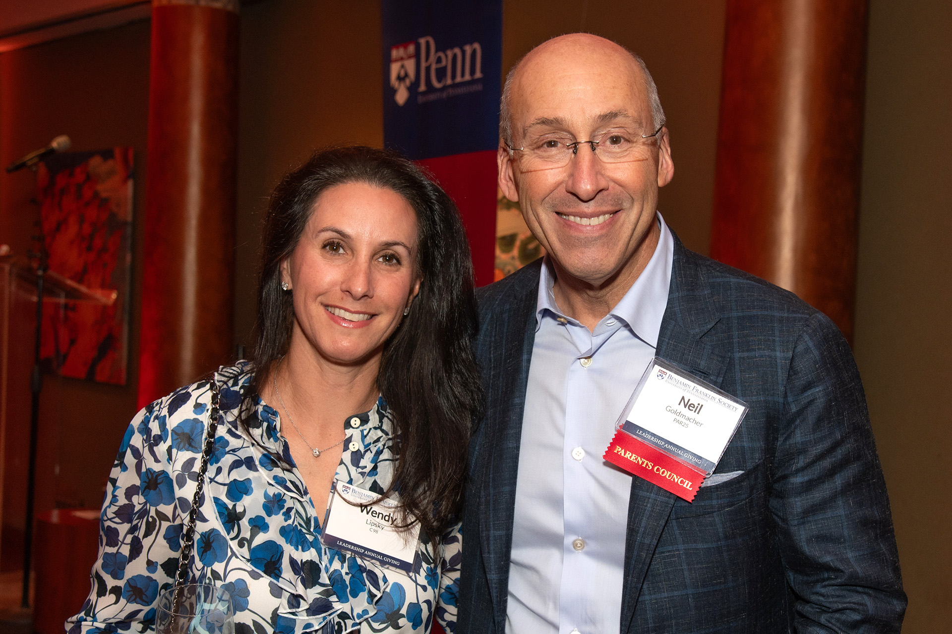 Two Penn alumni pose for a photo at a Benjamin Franklin Society event.