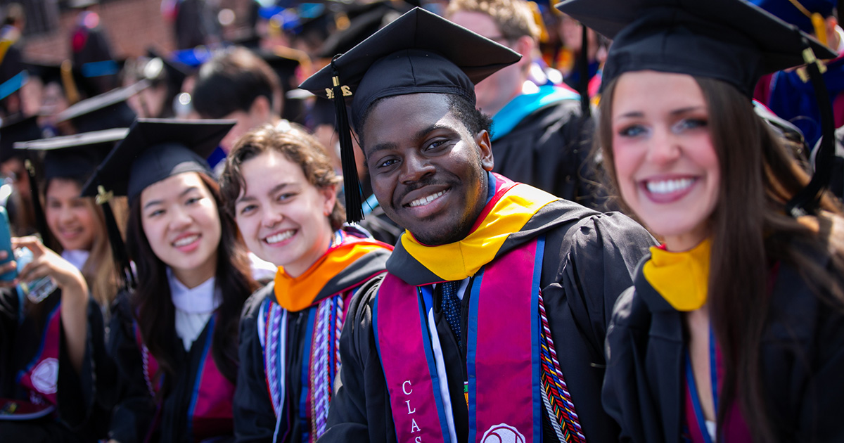 Joyful group of diverse graduates in cap and gowns at their commencement ceremony.