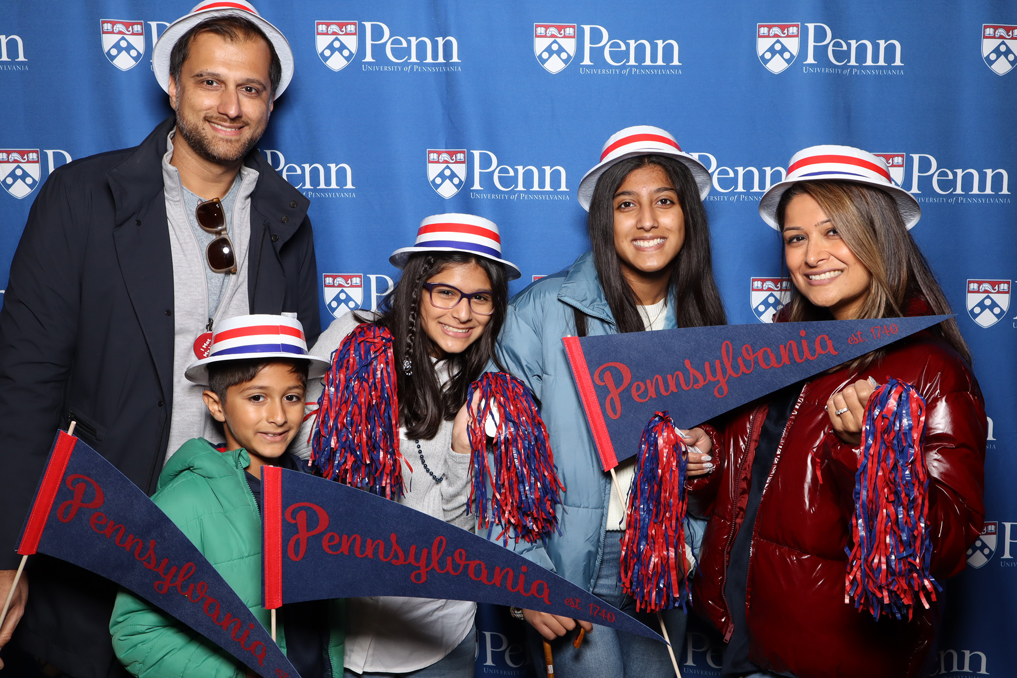 A Penn Alumni family shows their Penn pride and poses together for a photo during the 2022 Homecoming Brunch for members of the Benjamin Franklin Society at the University of Pennsylvania.