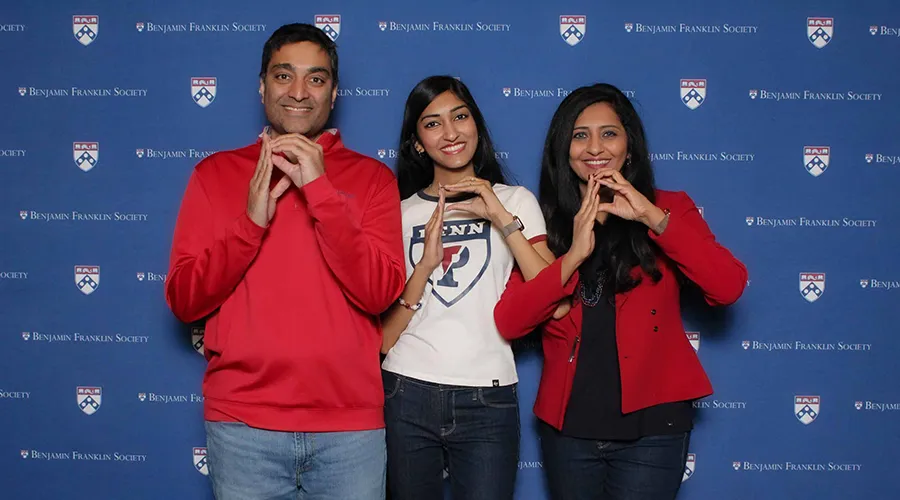Family posing at the 2025 BFS Homecoming Brunch in front of Benjamin Franklin Society backdrop
