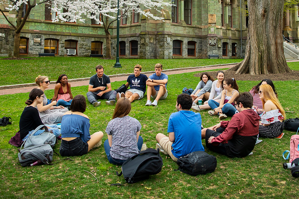Students sitting in a circle in front of College Hall on College Green at the University of Pennsylvania.