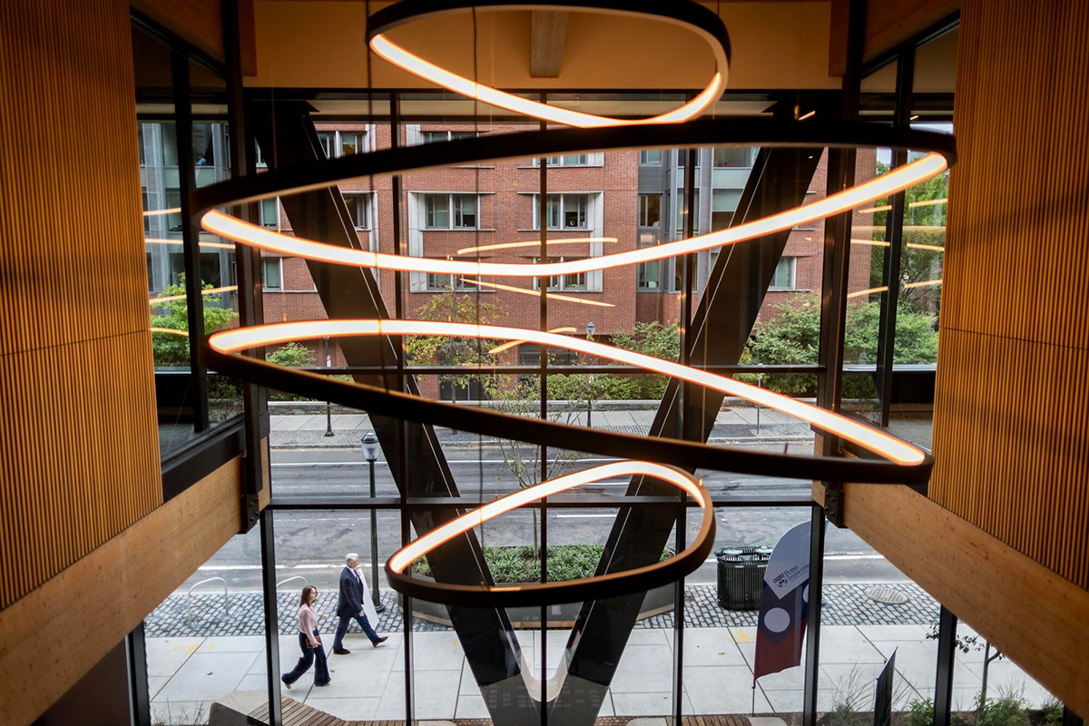 An artistically designed building interior, with the exterior walkway visible through the window.