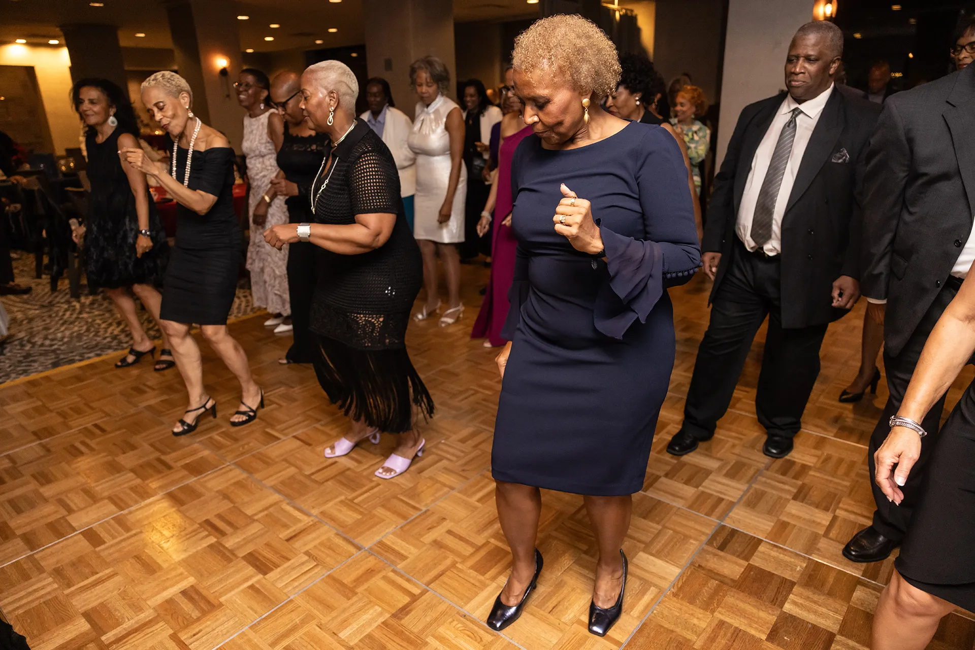 Class of 1980 University of Pennsylvania alumni in elegant attire doing a line dance together at their 45th reunion
