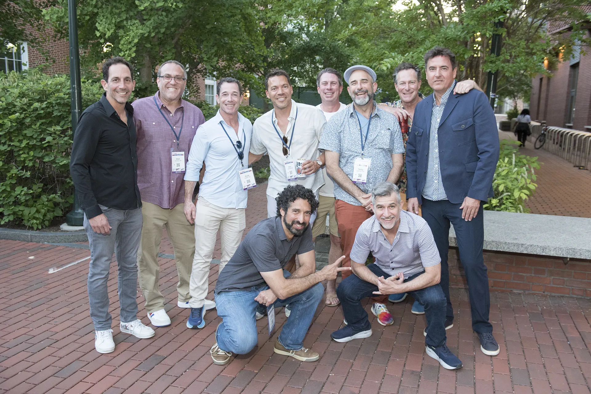 University of Pennsylvania alumni from the Class of 1995 posing together outdoors in a brick courtyard at their 30th reunion, some holding drinks and wearing reunion badges.