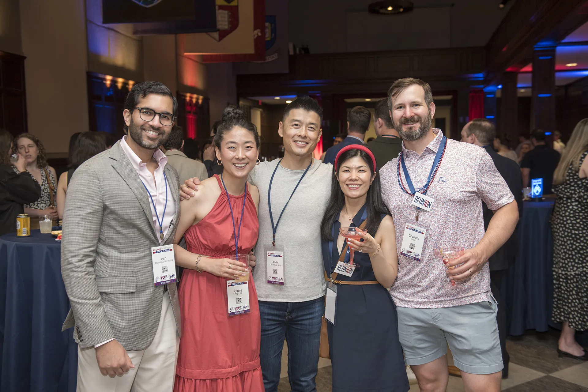 Five Penn alumni from the Class of 2010 raise cocktails and smile together at their 15th Reunion celebration reception