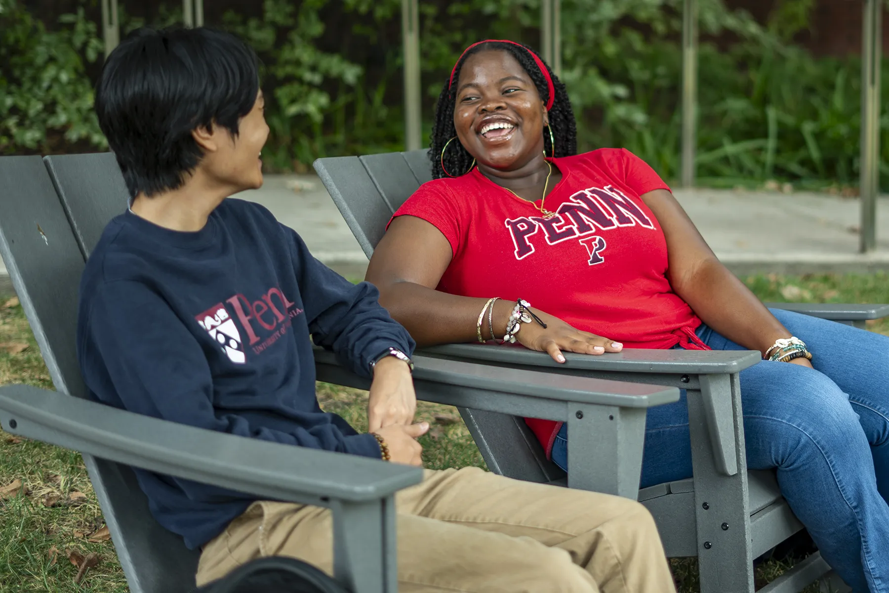Herinah Asaah smiling and talking with a fellow Penn student outdoors