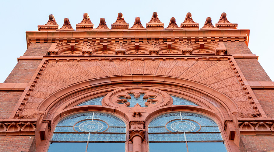A view from ground level of architectural details at the top of Fisher Fine Arts Library at the University of Pennsylvania