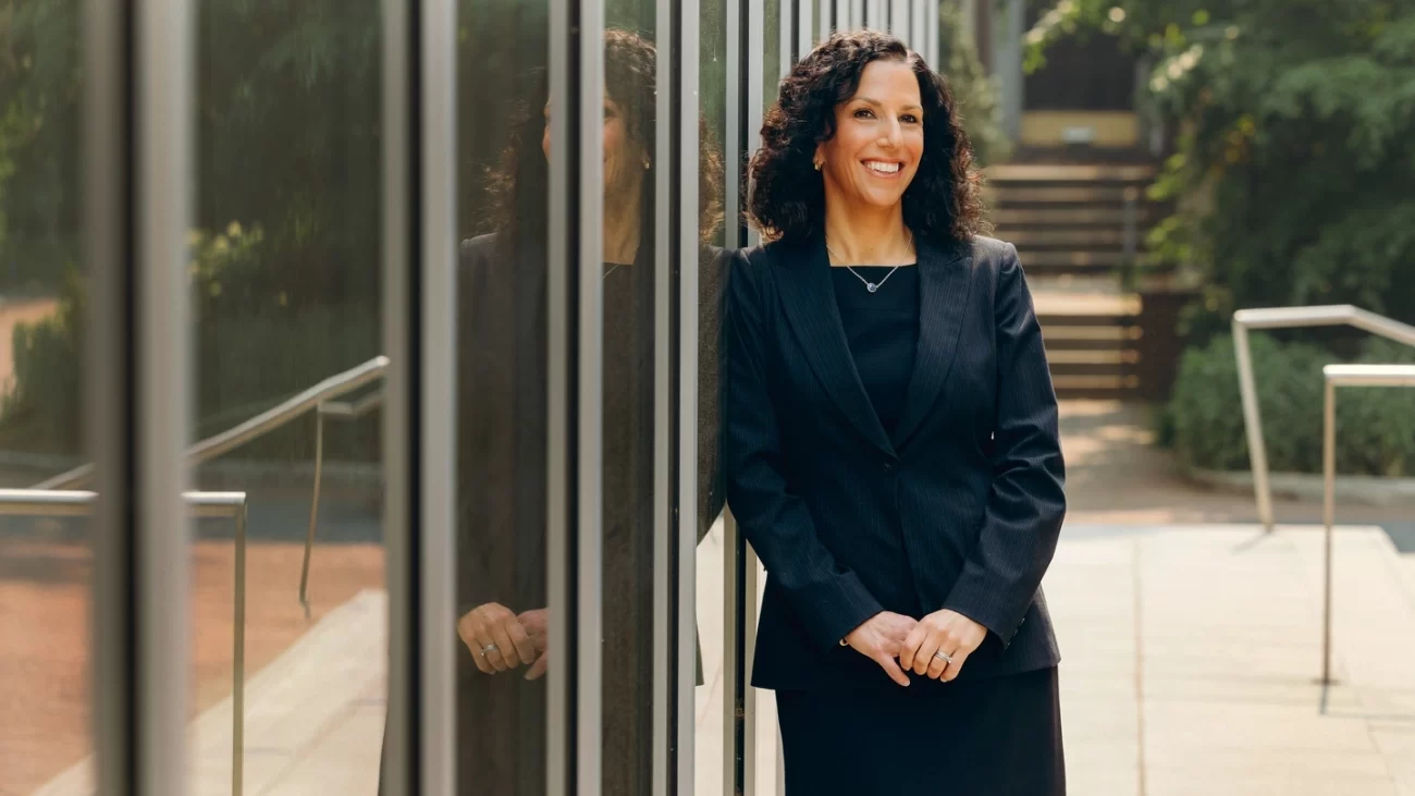 Katharine Strunk, shown standing outdoors and smiling in front of the Penn GSE building, is leading Penn GSE’s efforts in transforming education.