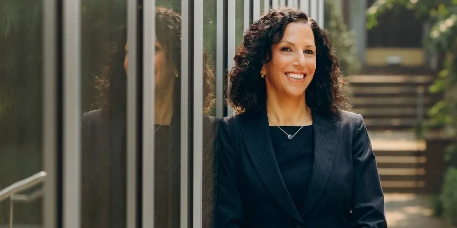 Katharine Strunk, shown standing outdoors and smiling in front of the Penn GSE building, is leading Penn GSE’s efforts in transforming education.