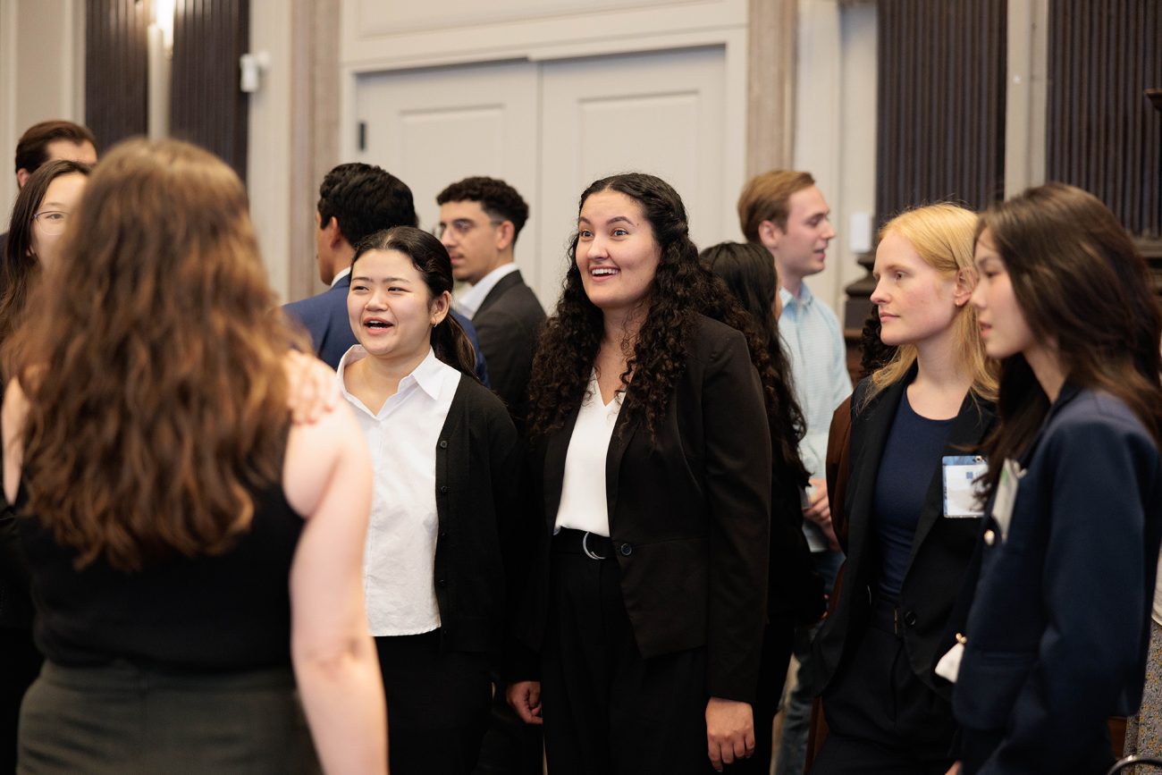 A group of students in professional attire actively engaging during a networking event.