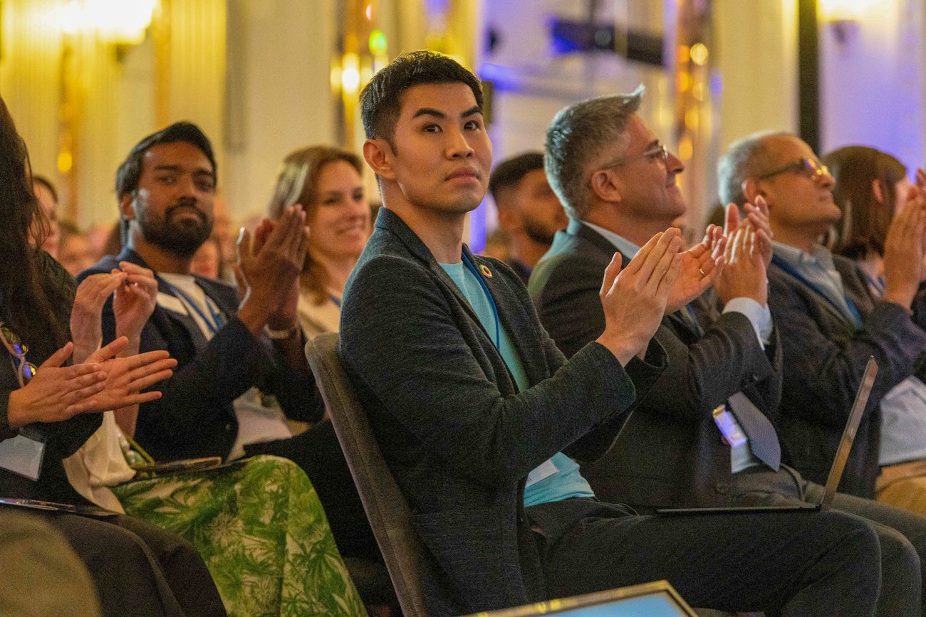 Audience members including Kenneth Kwok, C’04, W’04 (pictured at center), applaud the presenters during the Penn London symposium.