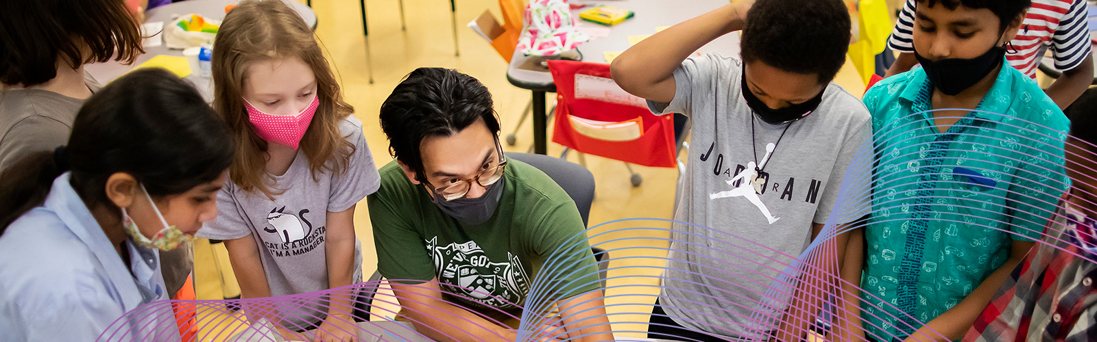 A teacher affiliated with the McGraw Center for Educational Leadership engages in coversation with young students in an elementary school.