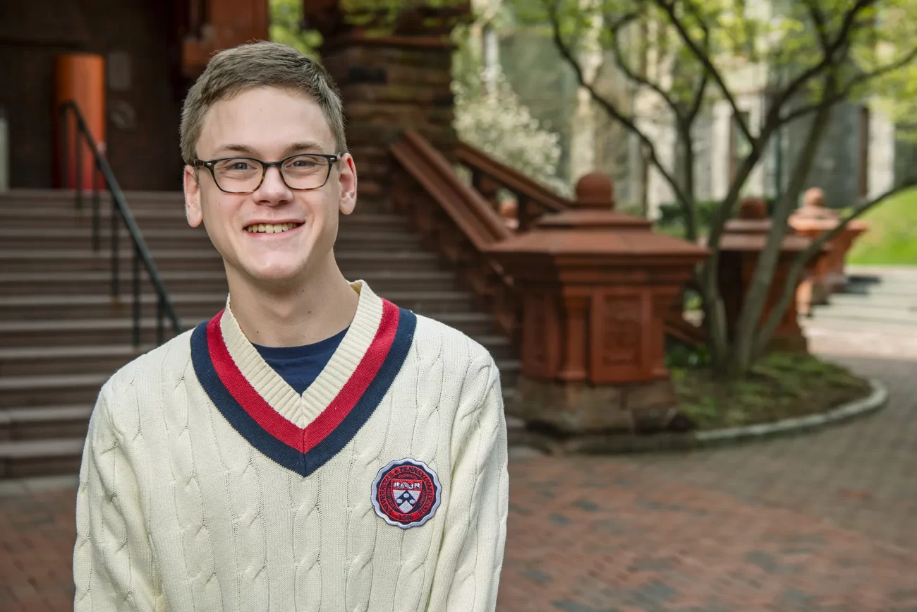 A portrait of Penn student Morgan Emery, C'26, near the historic red-brick steps of Fisher Fine Arts Library.