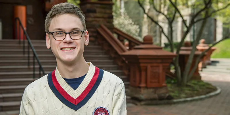 A portrait of Penn student Morgan Emery, C'26, near the historic red-brick steps of Fisher Fine Arts Library.