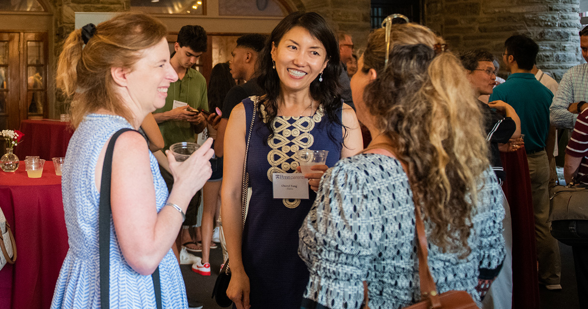 Three Penn Parents mingle and chat during a welcome event at Morris Arboretum & Gardens