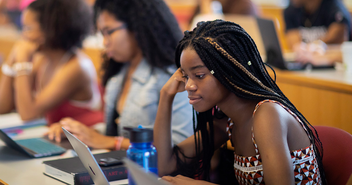 A Penn student takes notes during a class