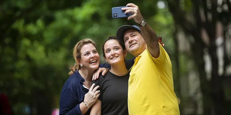 Smiling family takes a selfie on Penn’s campus, symbolizing their connection to the broader university community as proud supporters of their student.