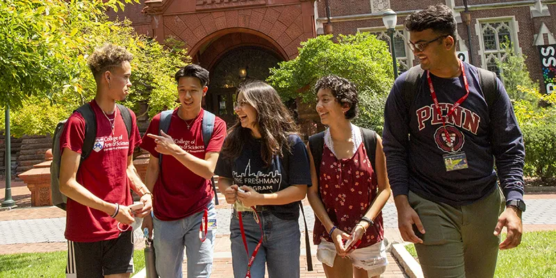 A group of Penn students walk and laugh together on campus, reflecting the supportive and inclusive community fostered by Penn First Plus.