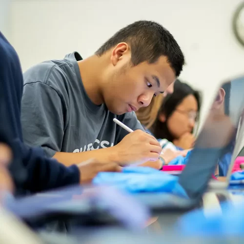 Penn students work intently in a lab classroom, using laptops and styluses, reflecting academic focus supported by The Penn Fund.