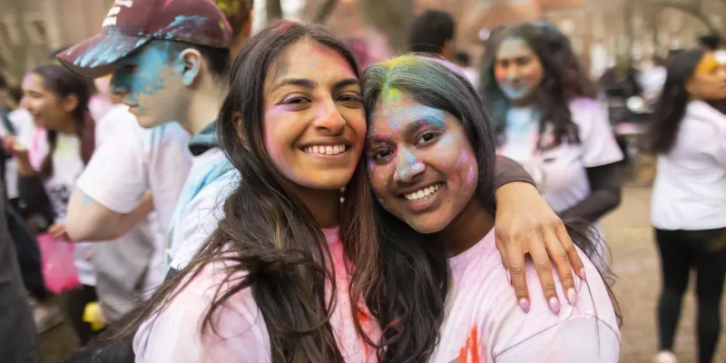 Friends embrace at a Holi festival event on Penn’s campus, highlighting the cultural celebrations and community made possible by donor support.