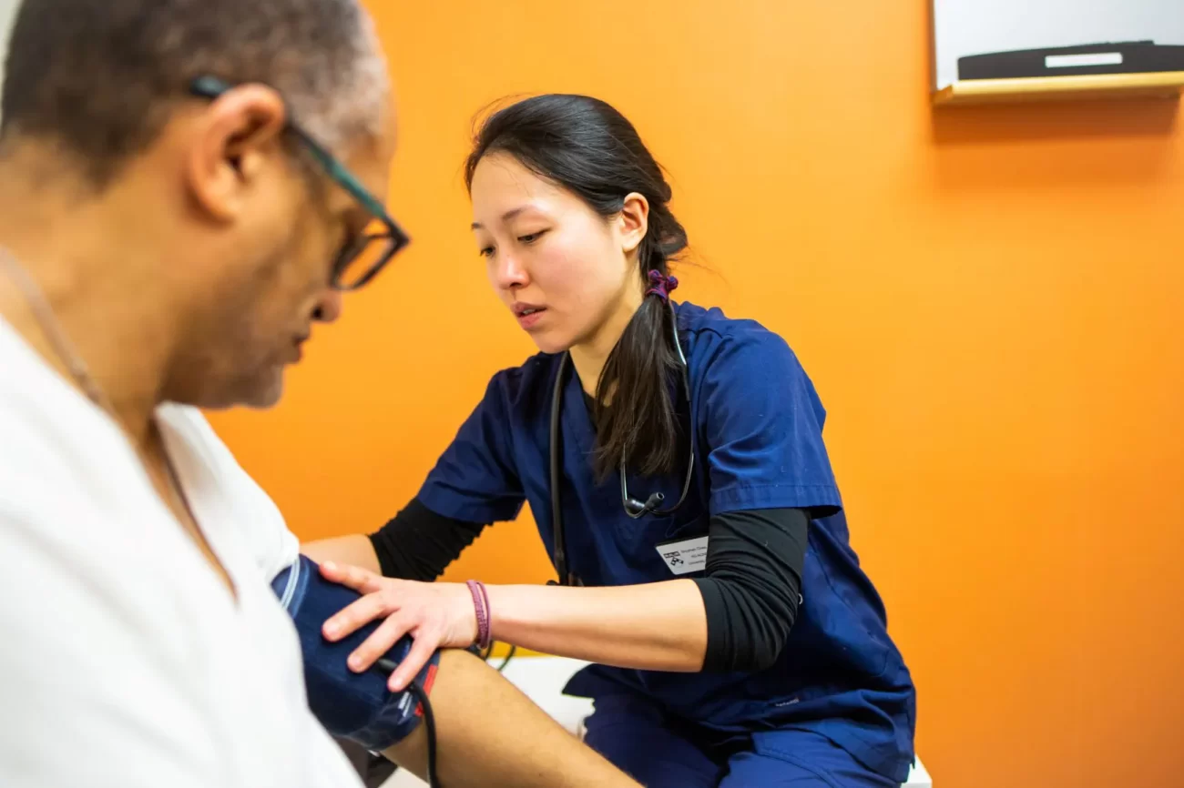 Nursing student taking a patient’s blood pressure during a clinical training session.