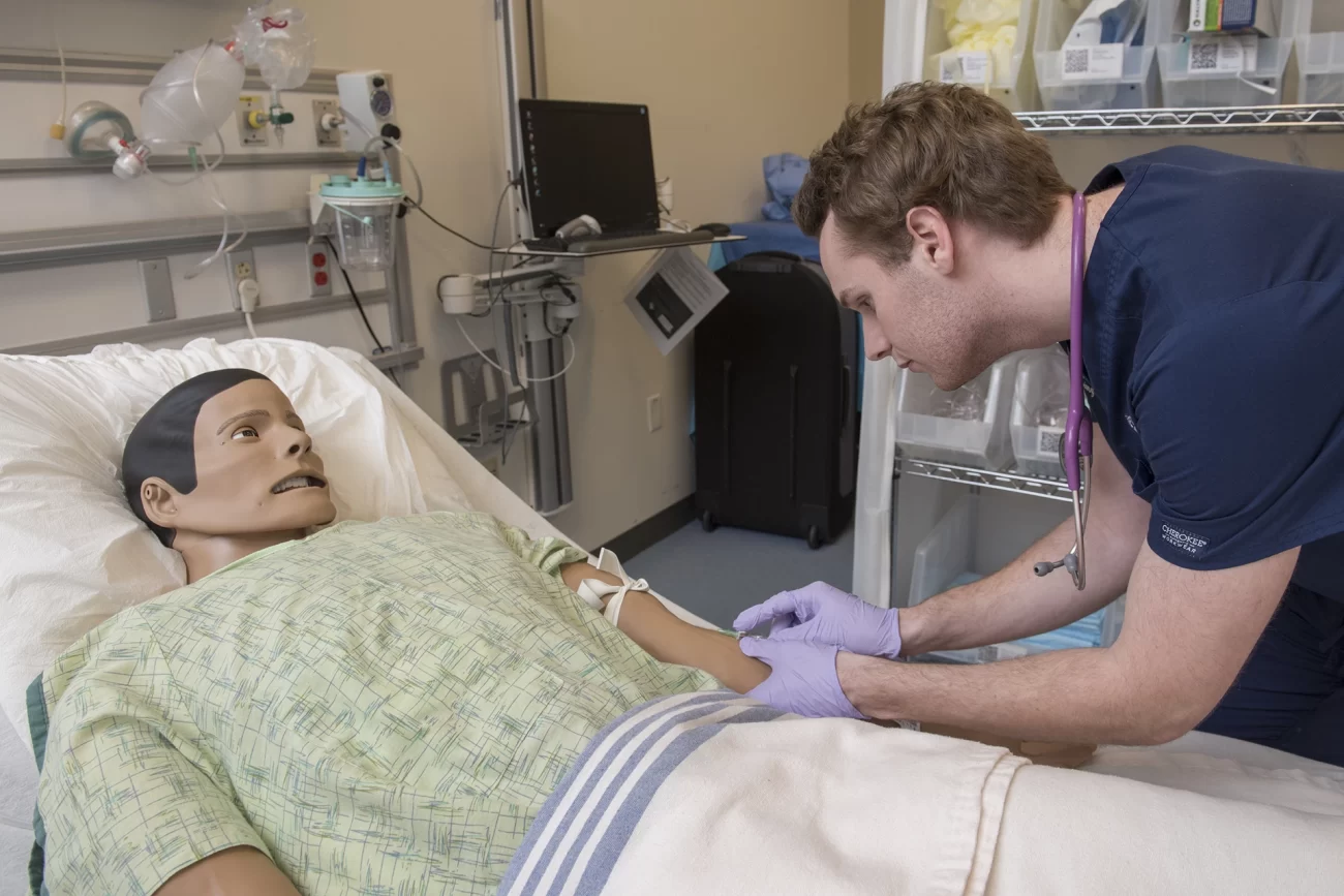 Penn Nursing student practices IV insertion on a lifelike manikin during a clinical simulation exercise.