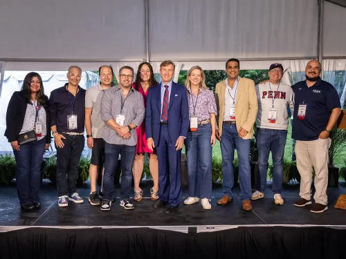 Members of the Class of 2000 stand on stage with Penn President J. Larry Jameson during their 25th reunion, celebrating their support for The Penn Fund.