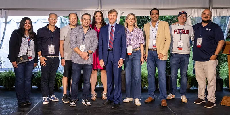 Members of the Class of 2000 stand on stage with Penn President J. Larry Jameson during their 25th reunion, celebrating their support for The Penn Fund.