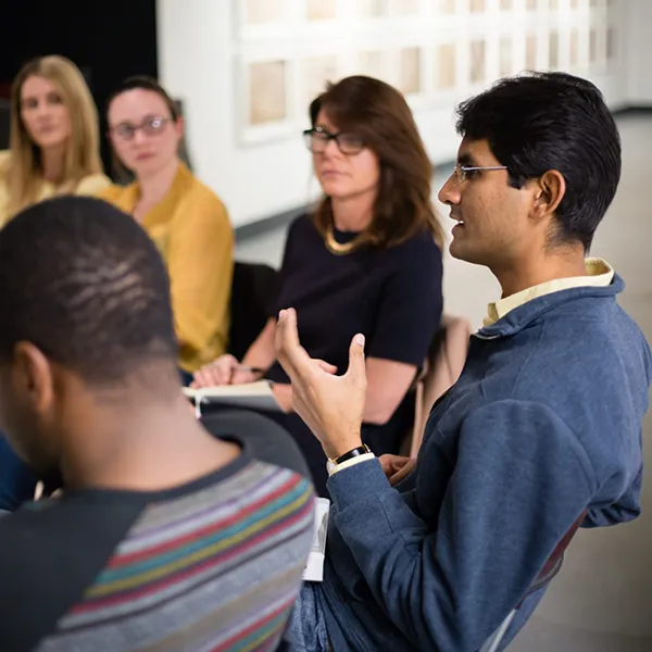 A group of people engaged in a discussion in a modern, well-lit setting.